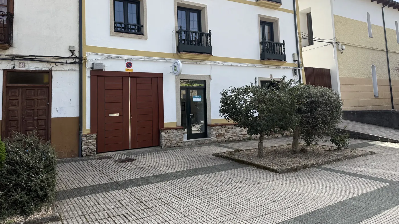 Fachada del edificio de la lavandería en la Avenida Díaz Ovelar, con olivos delante de la entrada